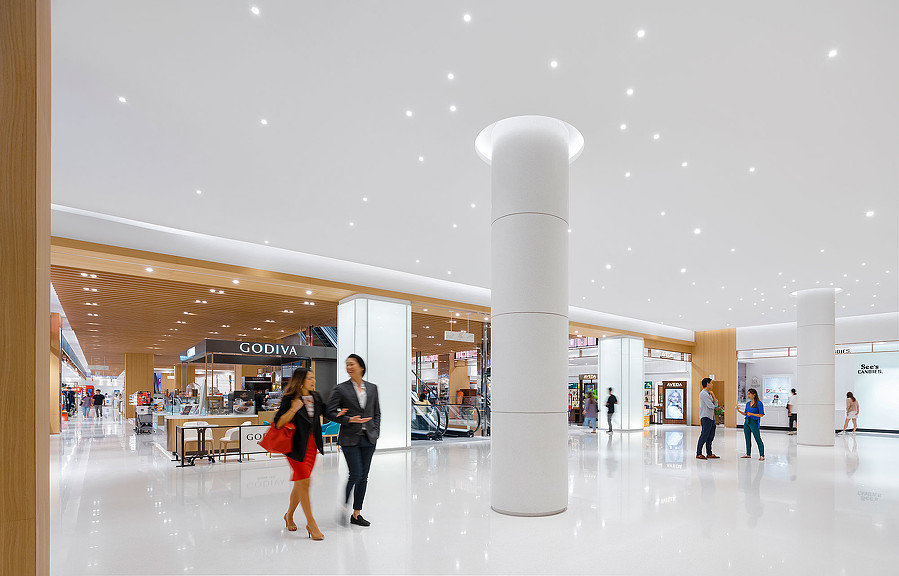 A man and woman walking in a large building.